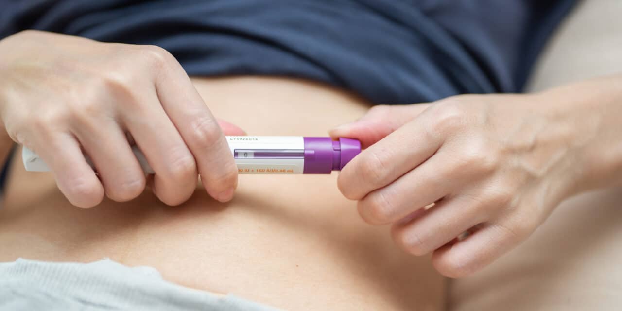 A woman adjust dosage of drug before injection at stomach or belly for increasing Ovarian Stimulation. IVF concept. Person in vitro fertilization treatment injection hormone for pregnancy