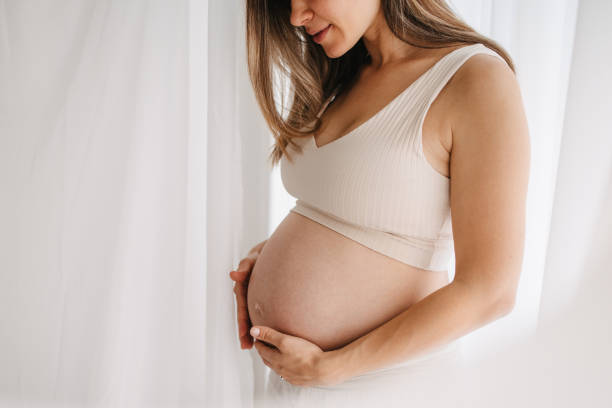 One woman, unrecognizable happy pregnant woman touching her belly.